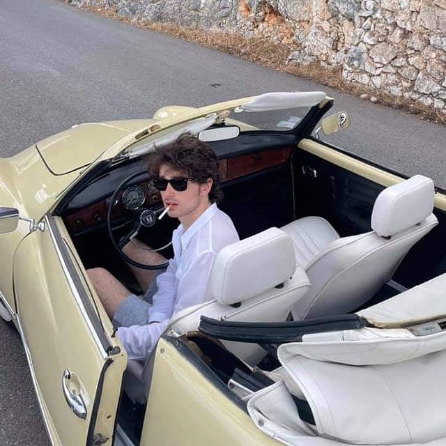 Elijah Hewson in a white shirt in his car.